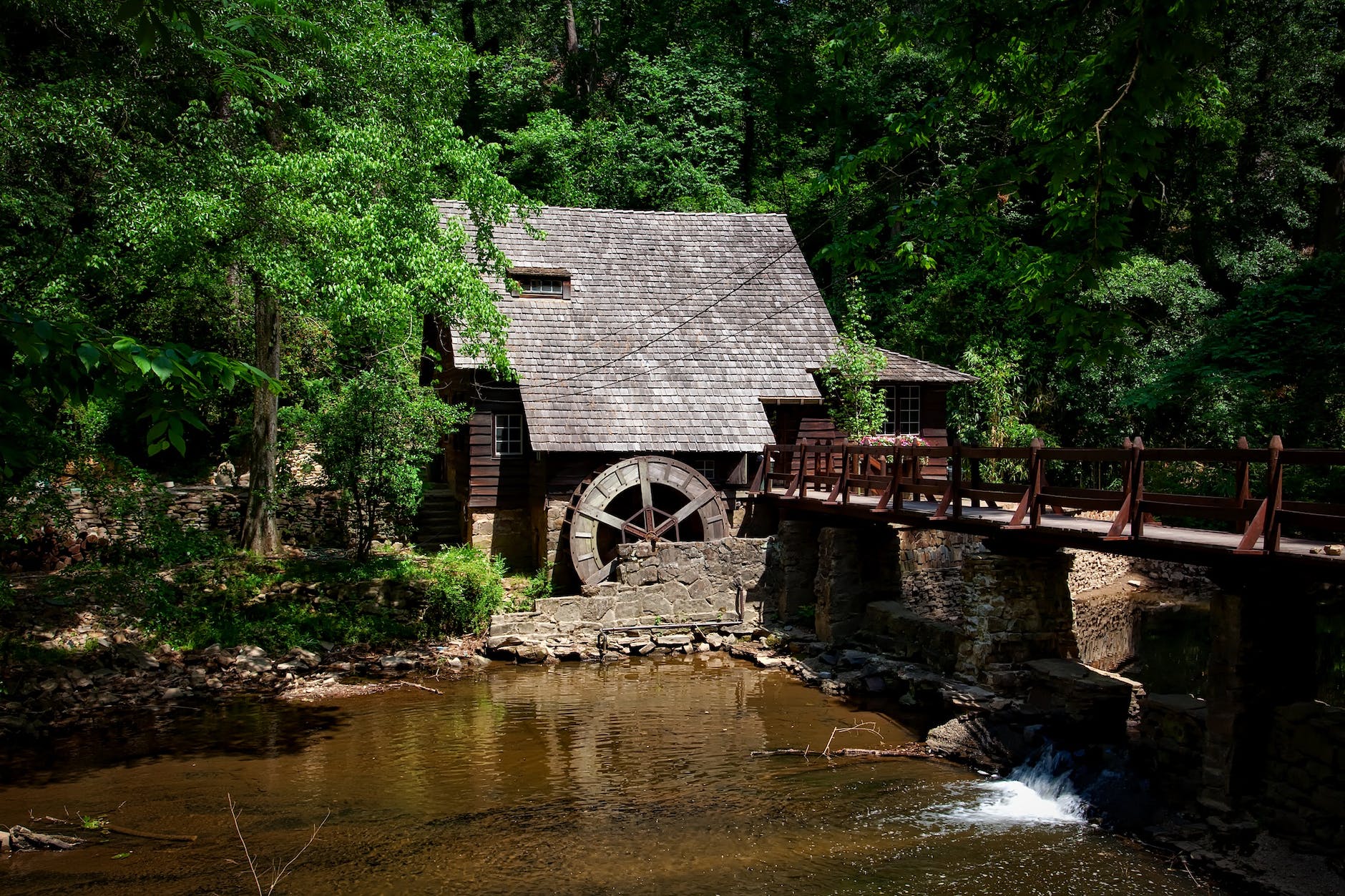 brown house near river trees and bridge
